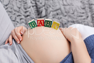 Pregnant young woman with cubes on her belly