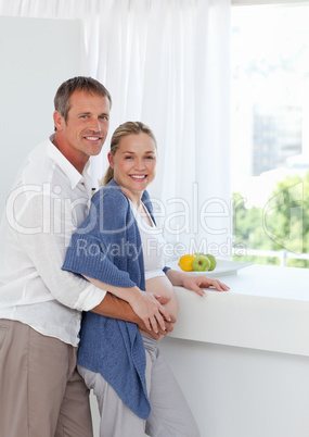 Young couple looking at the camera while they are hugging