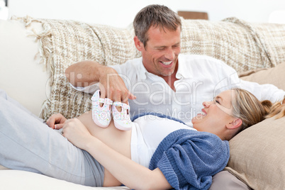 Lovers playing with childrens shoes at home