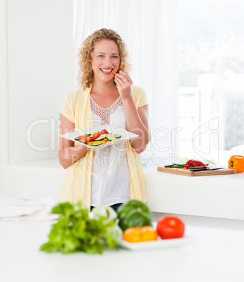 Beautiful woman is eating vegetables
