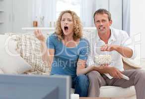 Lovers watching tv in the living room at home