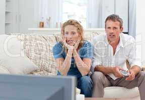 Lovers watching tv in the living room at home