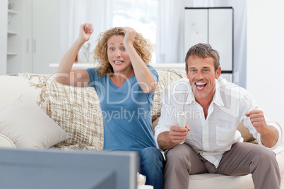Lovers watching tv in the living room at home