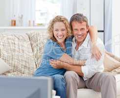 Lovers watching tv in the living room at home