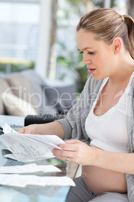 Worried pregnant woman calculating her domestic bills