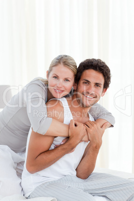 Lovely couple hugging on their bed