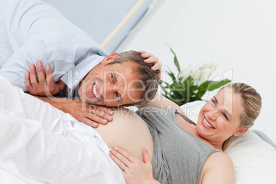 Man listening to his wife's  belly