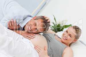 Man listening to his wife's  belly