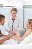 Pregnant woman with her husband listening to the nurse