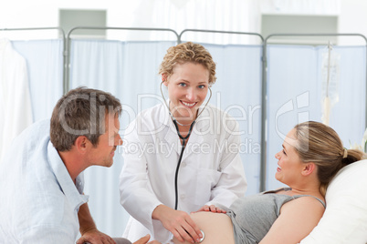 Pregnant woman with her husband listening to the nurse