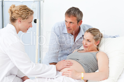 Pregnant woman with her husband listening to the nurse Pregnant woman with her husband listening to the nurse