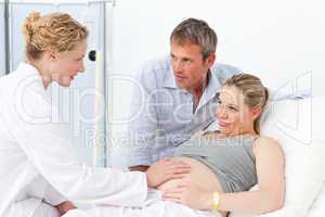 Pregnant woman with her husband listening to the nurse