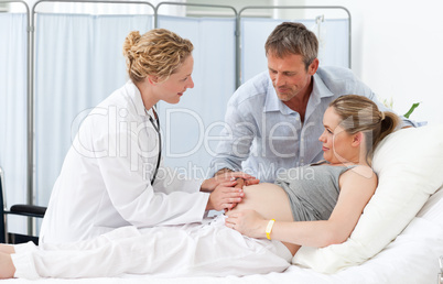 Pregnant woman with her husband listening to the nurse