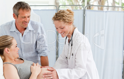 Pregnant woman with her husband listening to the nurse