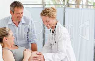 Pregnant woman with her husband listening to the nurse