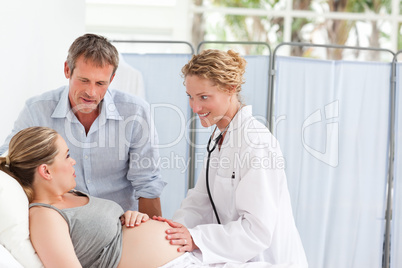 Pregnant woman with her husband listening to the nurse