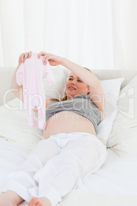 Pretty pregnant woman with childrens clothes