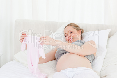 Pretty pregnant woman with childrens clothes