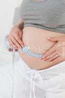 Close up of a woman measuring her belly