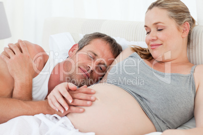 Husband listening to his wife's belly