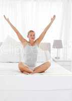 Beautiful woman practicing yoga on her bed