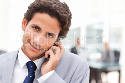 Charming businessman phoning in his office