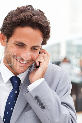 Charming businessman phoning in his office