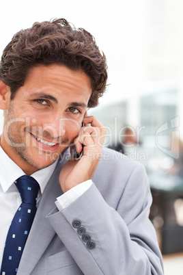 Charming businessman phoning in his office