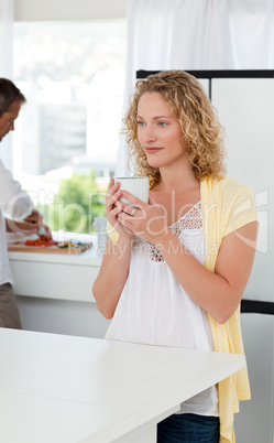 Pretty woman drinking tea in her kitchen