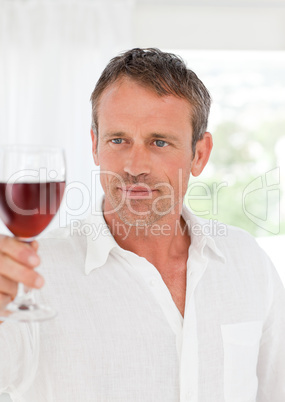 Man with his wineglass in his kitchen