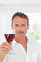 Man with his wineglass in his kitchen