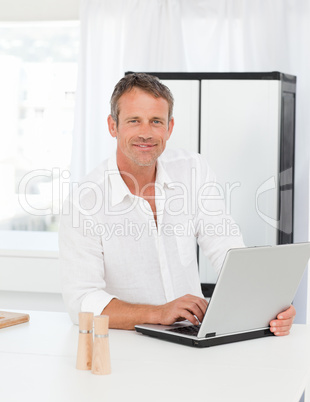 Man working on his laptop in his kitchen
