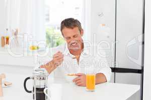 Handsome man having his breakfast in the kitchen