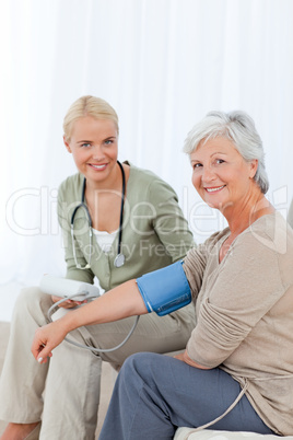 Lovely doctor taking the blood pressure of her patient