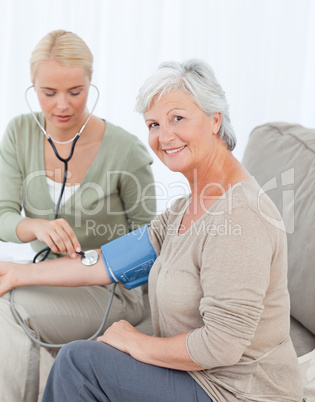 Lovely doctor taking the blood pressure of her patient