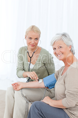 Lovely doctor taking the blood pressure of her patient