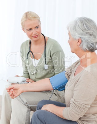 Lovely doctor taking the blood pressure of her patient