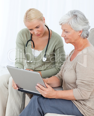 Senior with her doctor working on the laptop