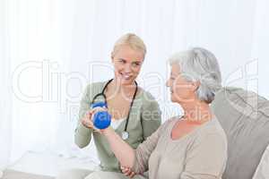 Beautiful nurse helping her patient to do exercises