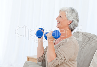 Senior doing her exercises on her sofa