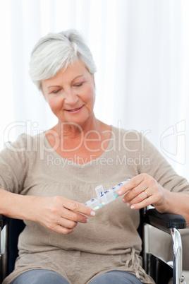 Senior in wheelchair with pills