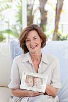 Mature woman showing her picture of her grandchild