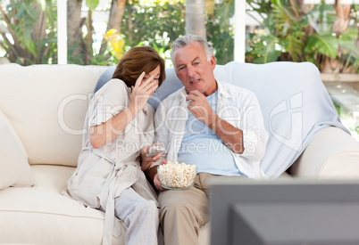 Seniors watching tv at home