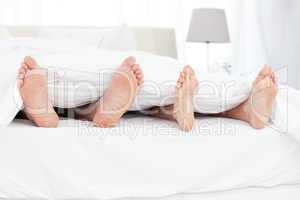 Couple's feet in the bed