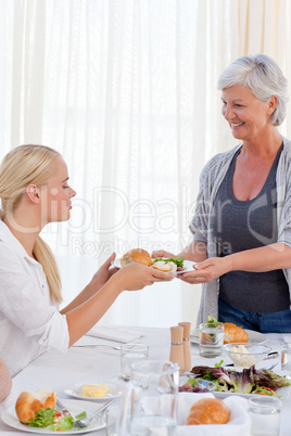 Aged woman serving her daughter