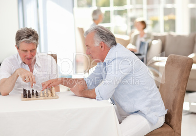 Seniors playing chess in the living room