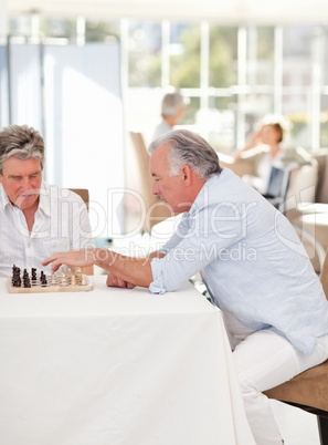 Seniors playing chess in the living room