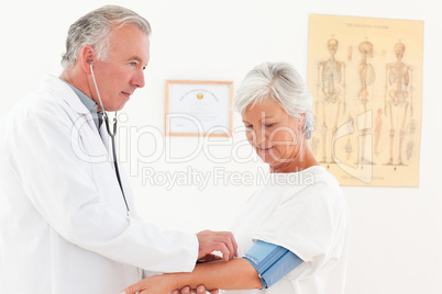 Doctor taking the blood pressure of his patient