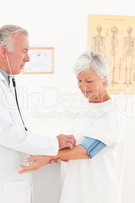 Doctor taking the blood pressure of his patient