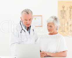 Doctor and his patient looking at the laptop